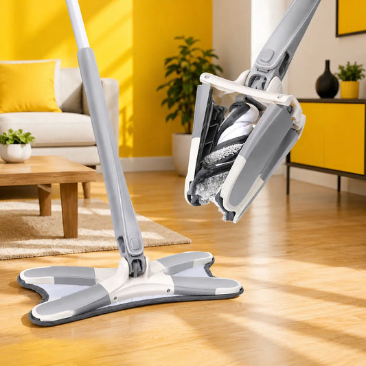 A gray and white floor mop with a flexible pad is shown on a wooden floor in a bright living room, with the mop head lifted slightly to show the underside and cleaning pad attachment.